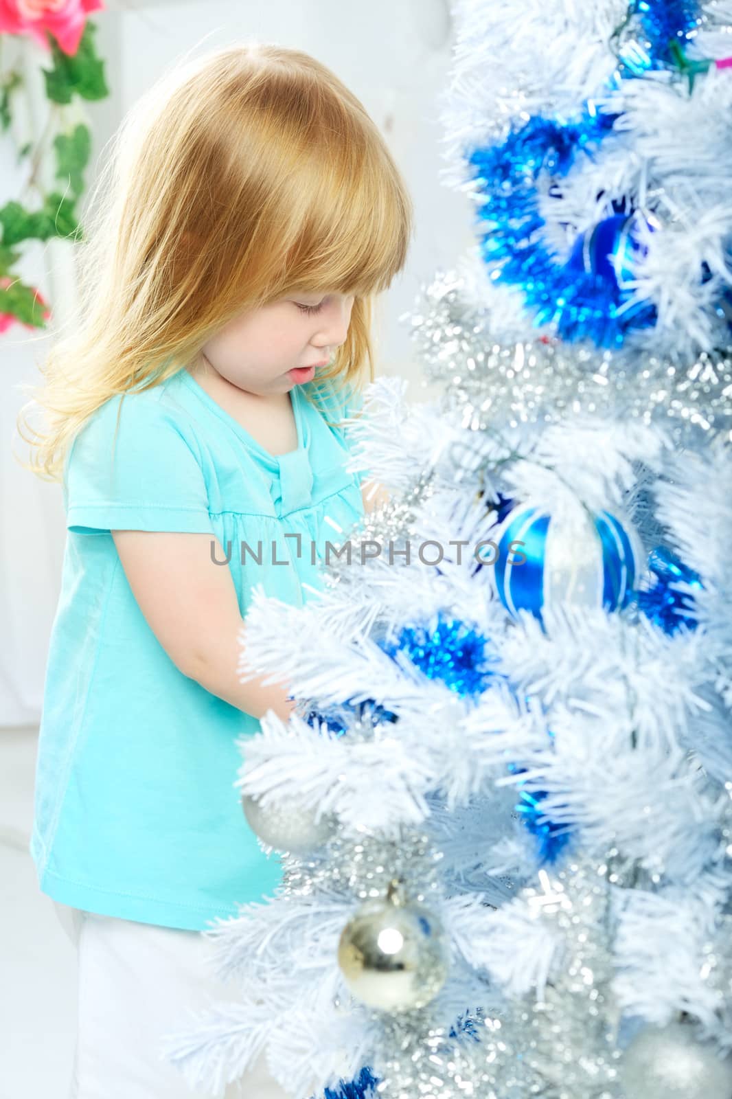 beautiful happy small girl decorate christmas tree