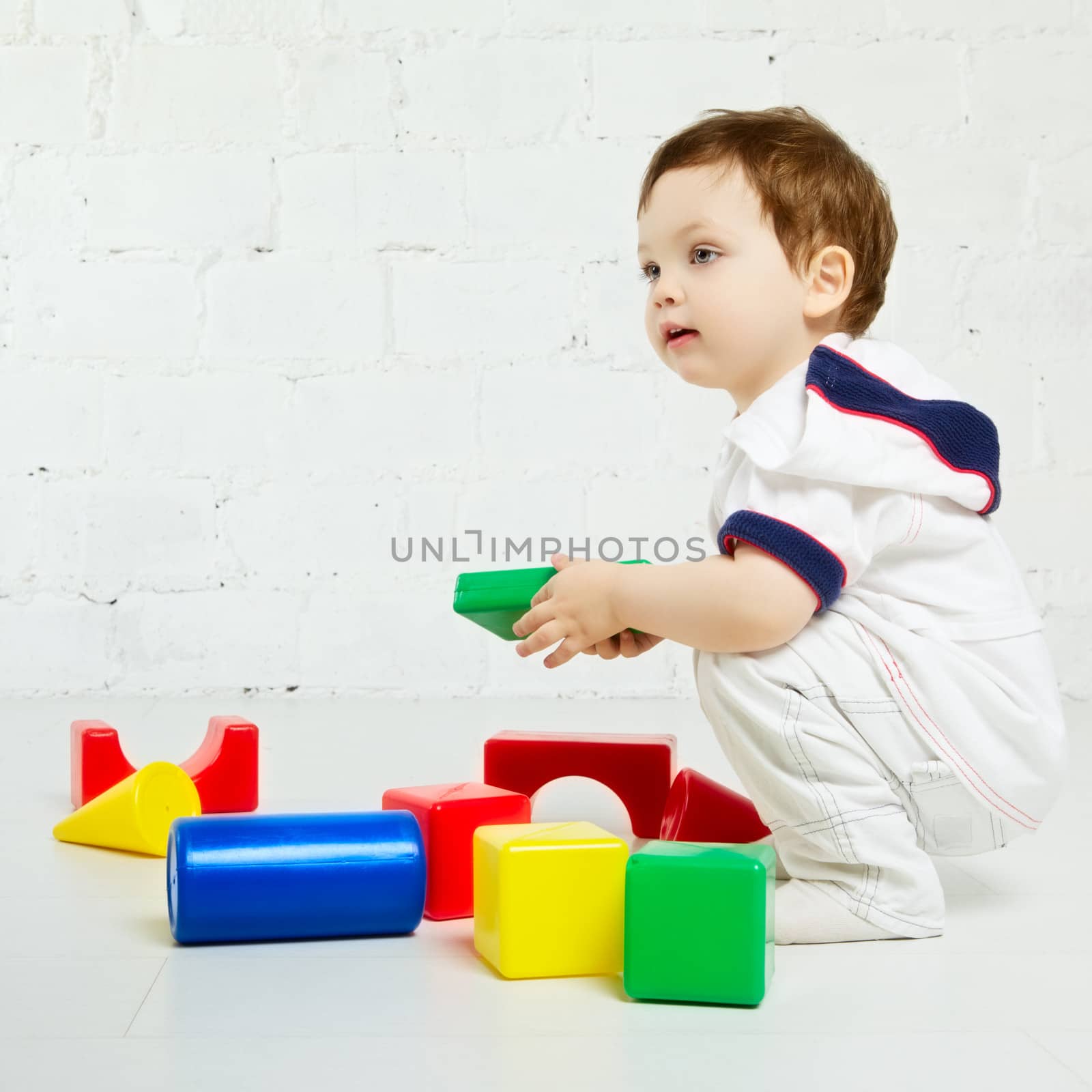 beautiful little boy playing with colorful cubes