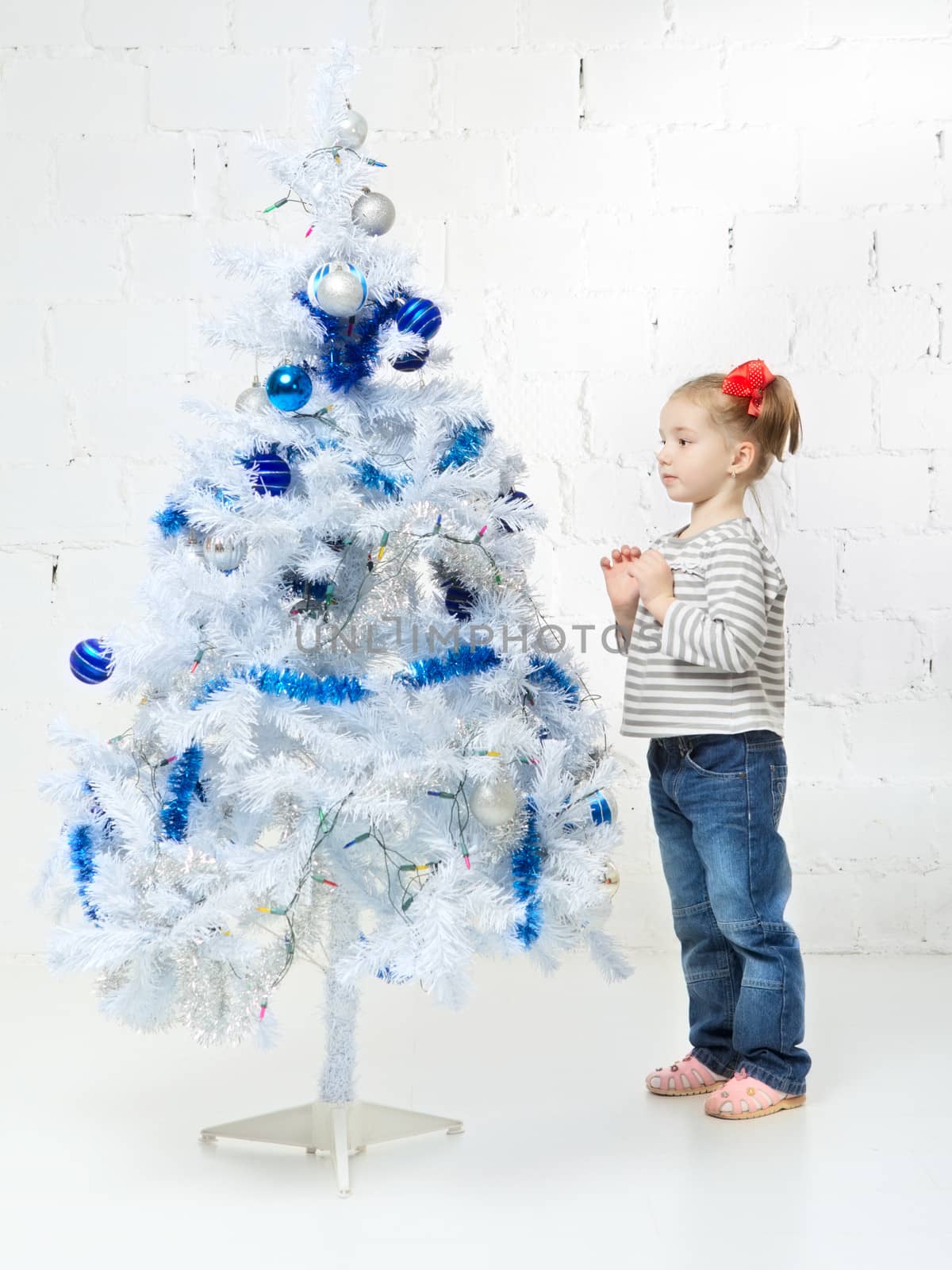 beautiful happy small girl decorate christmas tree