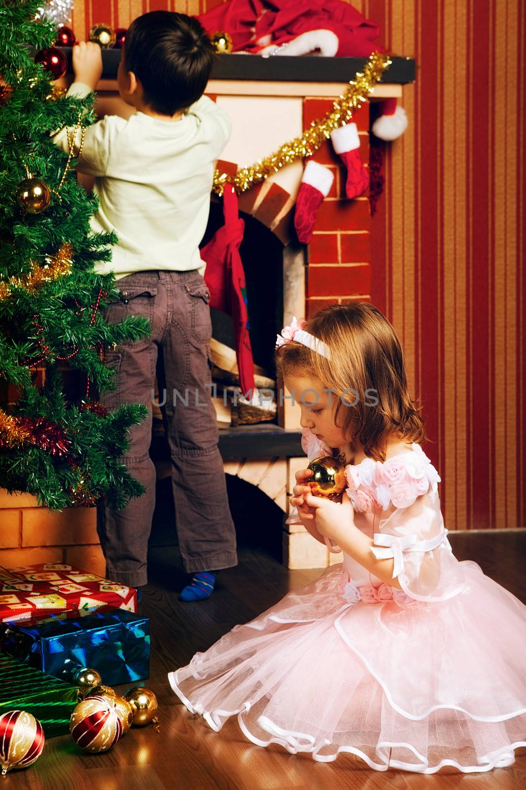 beautiful boy and girl decorate christmas tree