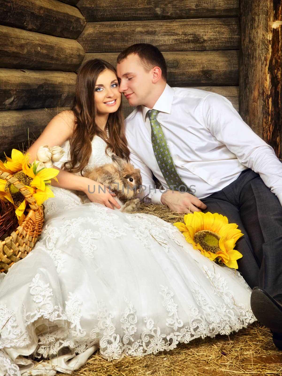 charming bride and groom in hayloft with rabbit
