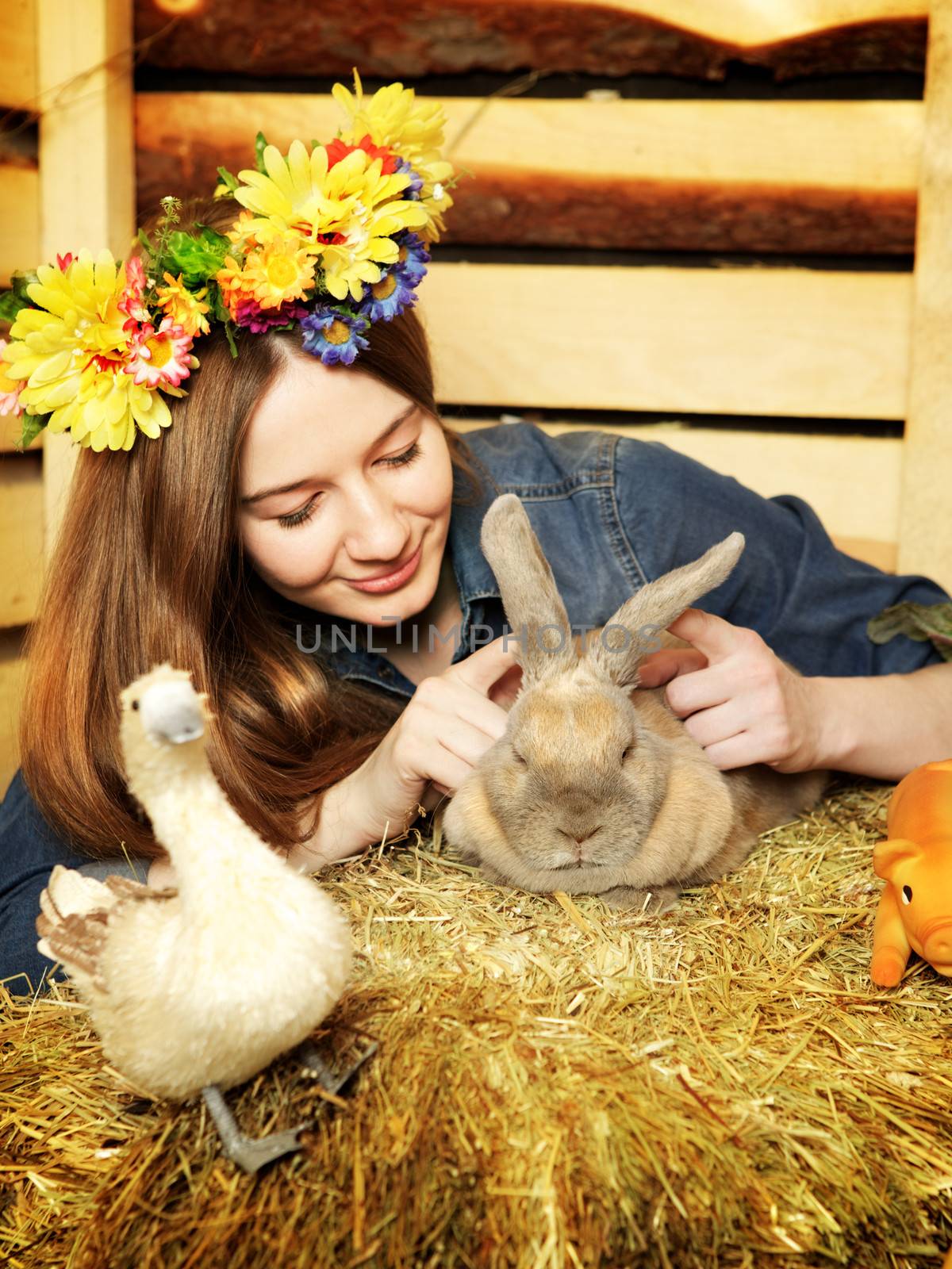 beautiful girl with rabbit on hayloft at summer day