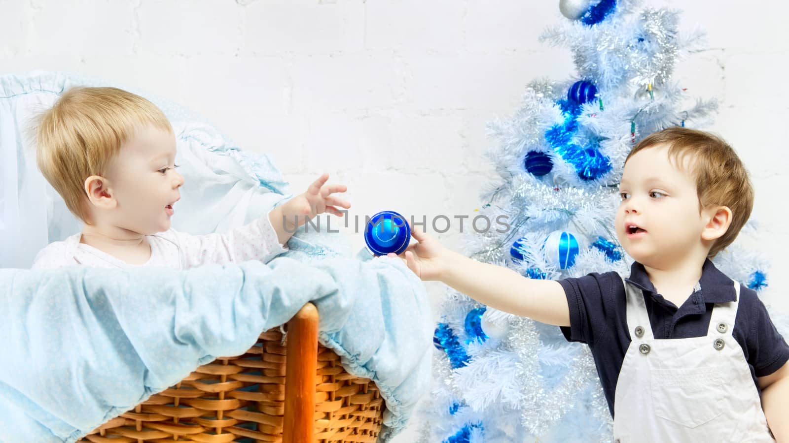 little boy and toddler in cradle playing