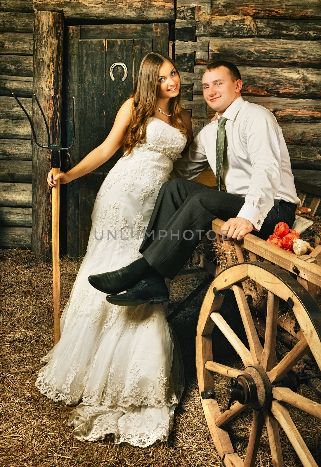 charming bride and groom in hayloft at summer day