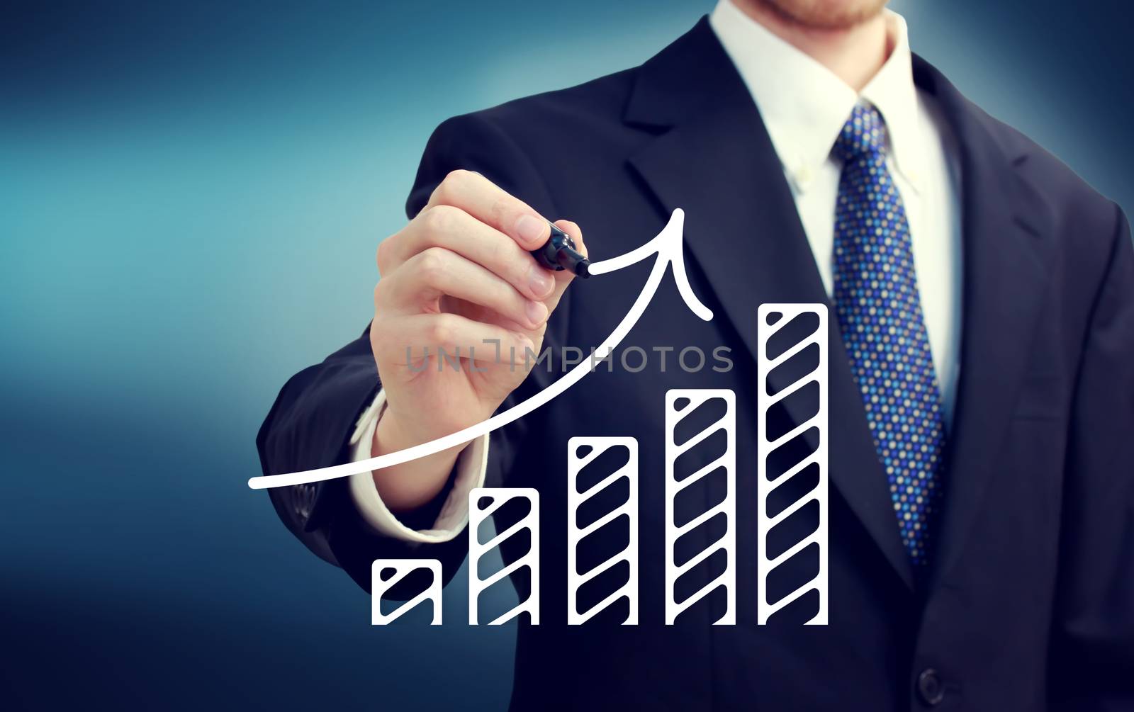Businessman drawing a rising arrow over the bar graph