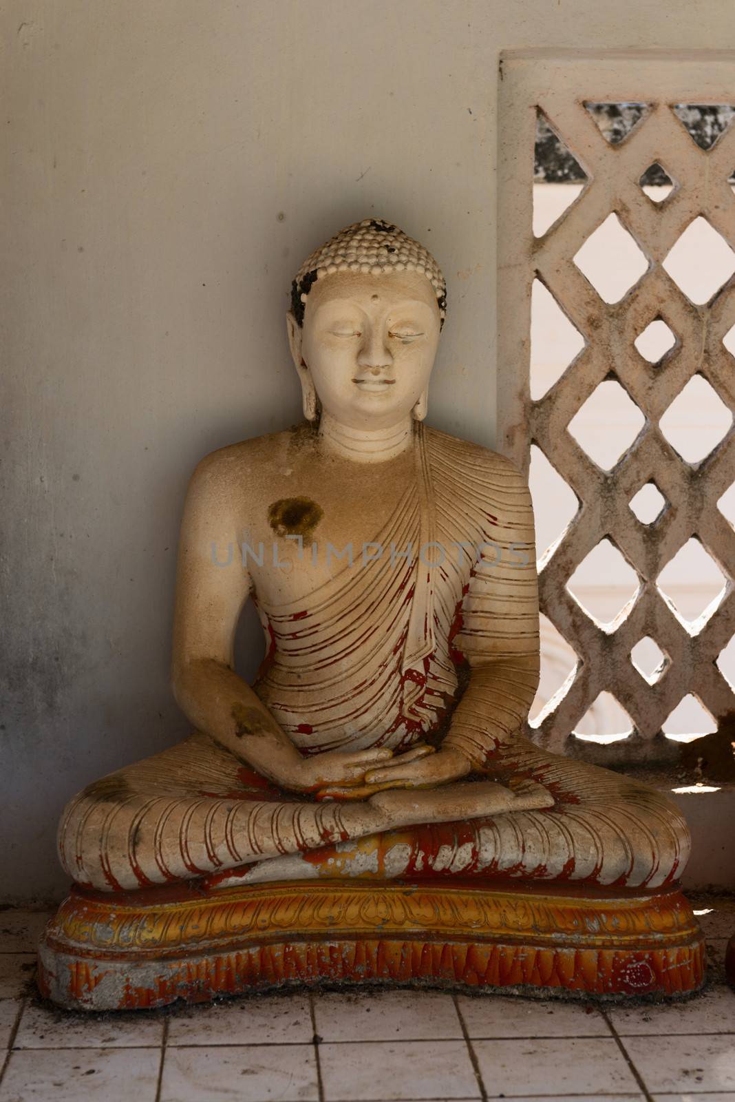 Small grunge Buddha statue in a niche, Avukana, Sri Lanka