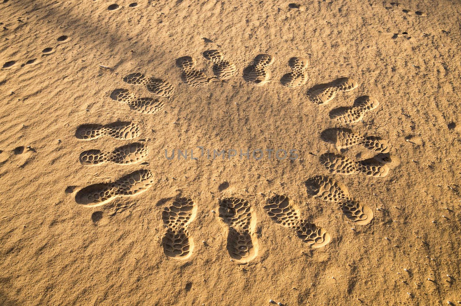 Circle of footprints in desert at dusk