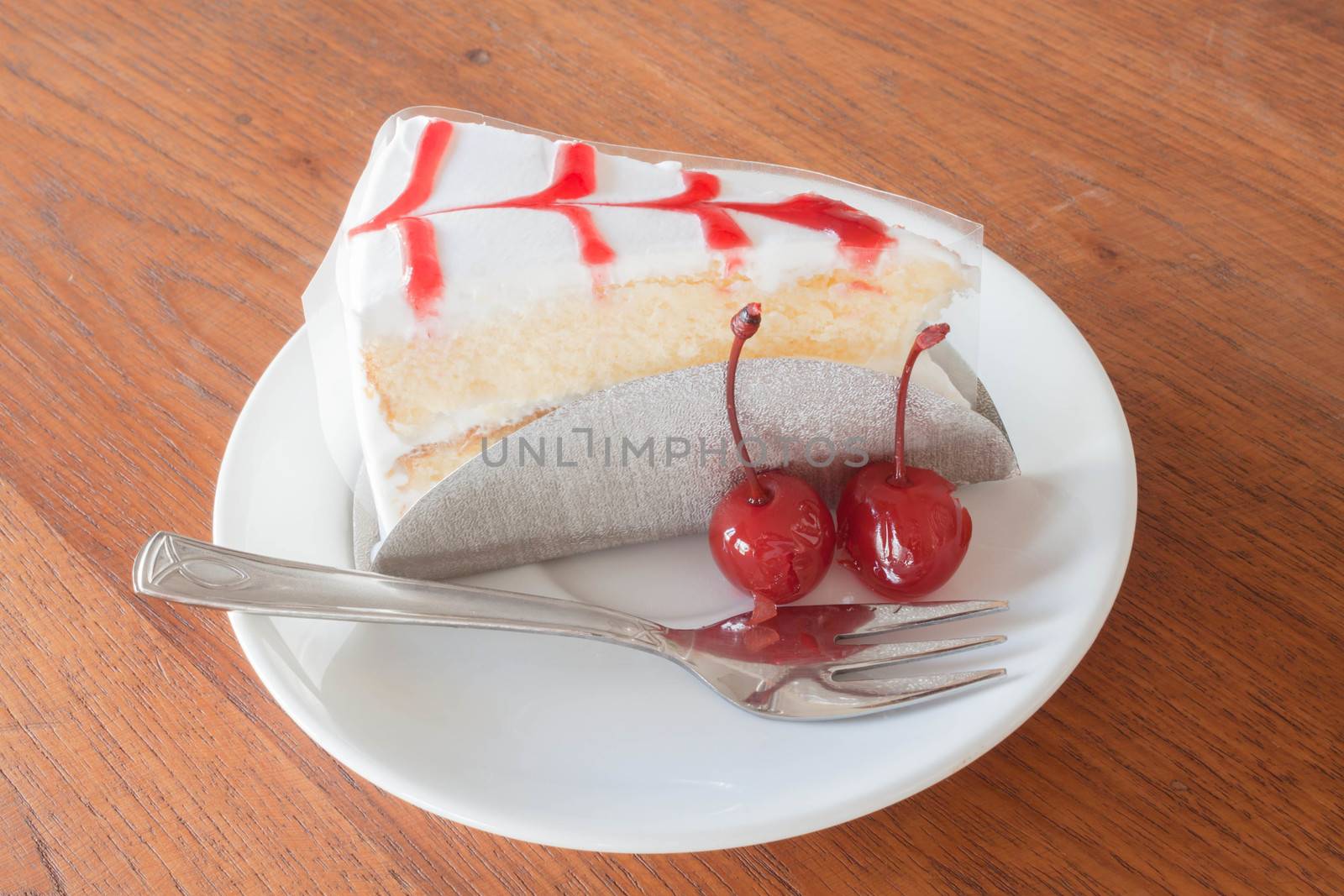 Vanilla cake with cherry on wood background by punsayaporn