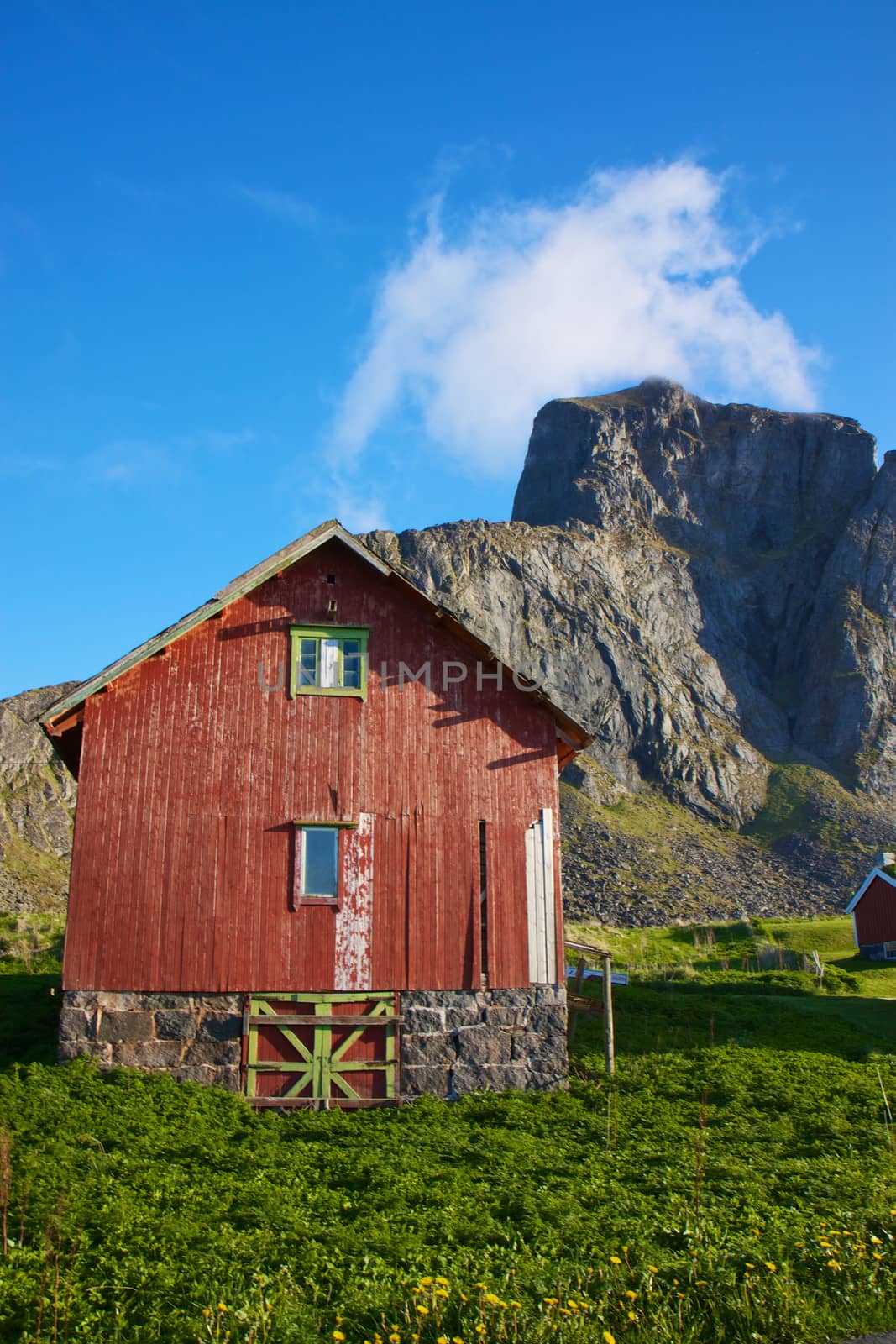 Traditional norwegian shed under the cliffs on island of Vaeroy, Lofoten, Norway