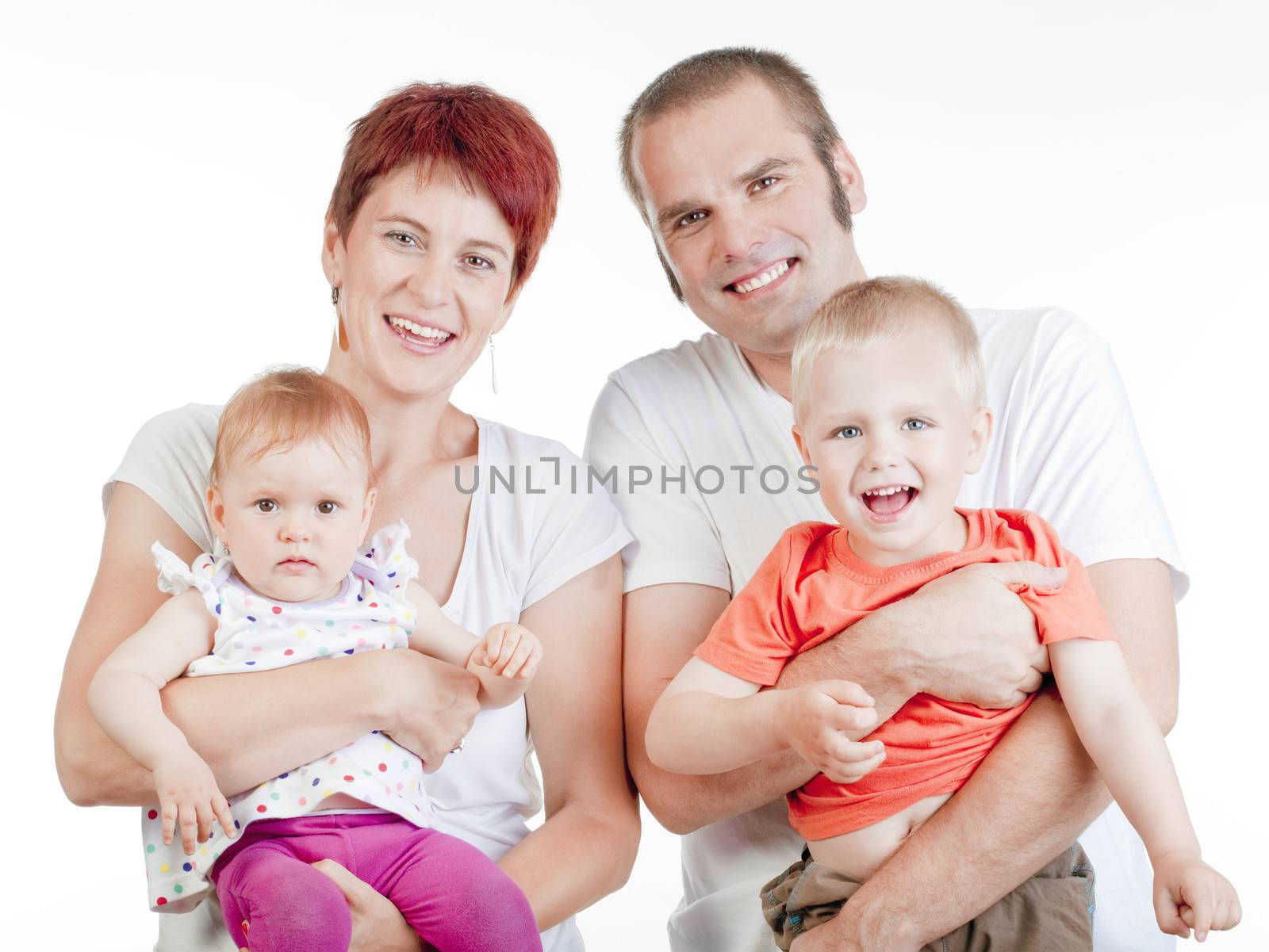 happy parents with their two children looking at the camera, smiling - isolated on white