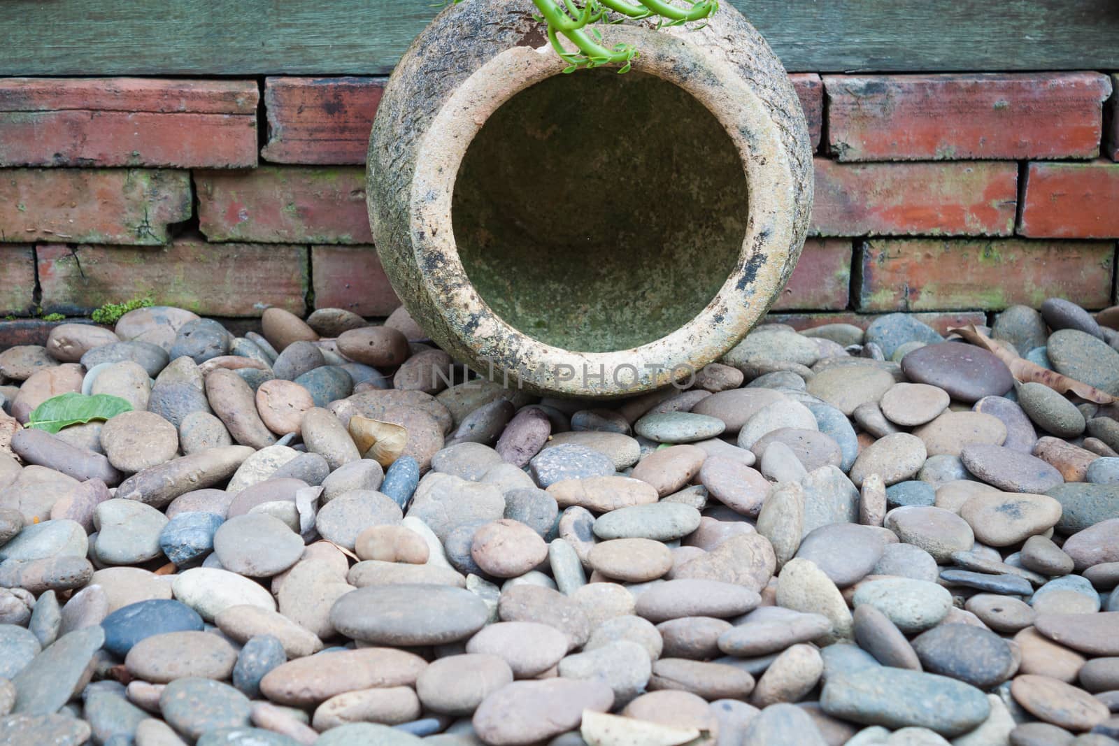 Garden earthen jar decorated on brown pebble