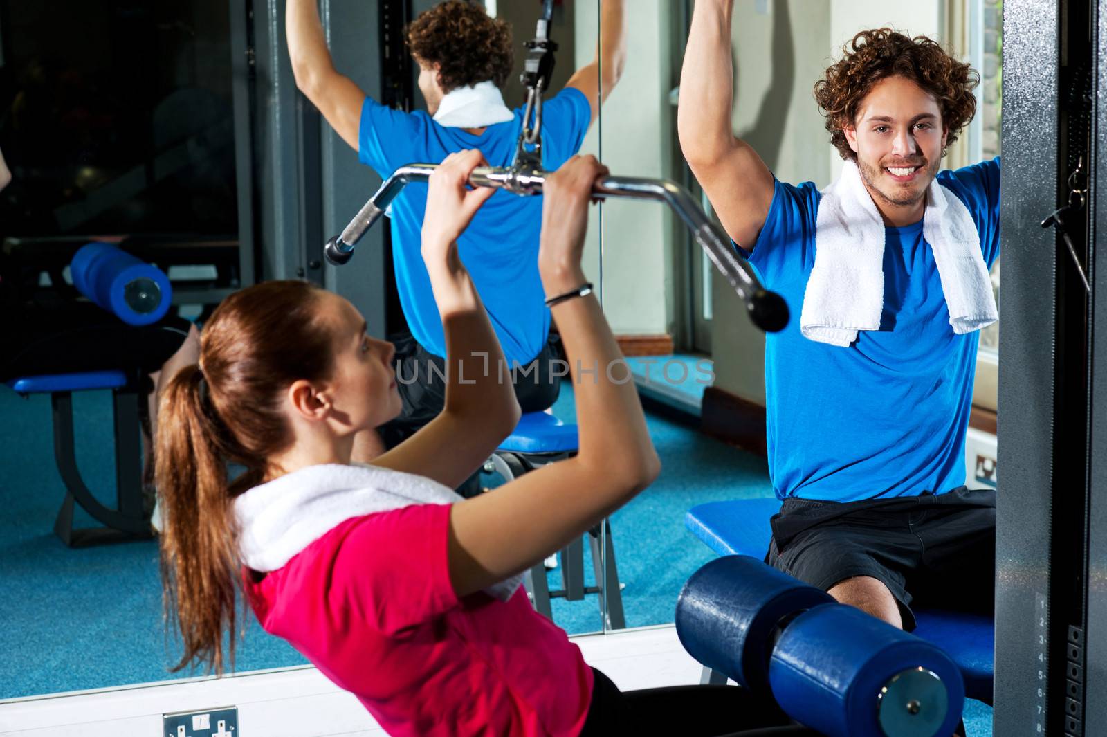 Handsome man and attractive woman working out in gym