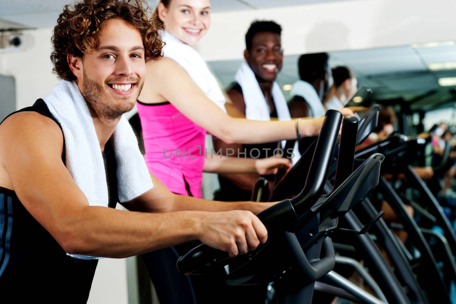 People at gym working out happily by stockyimages