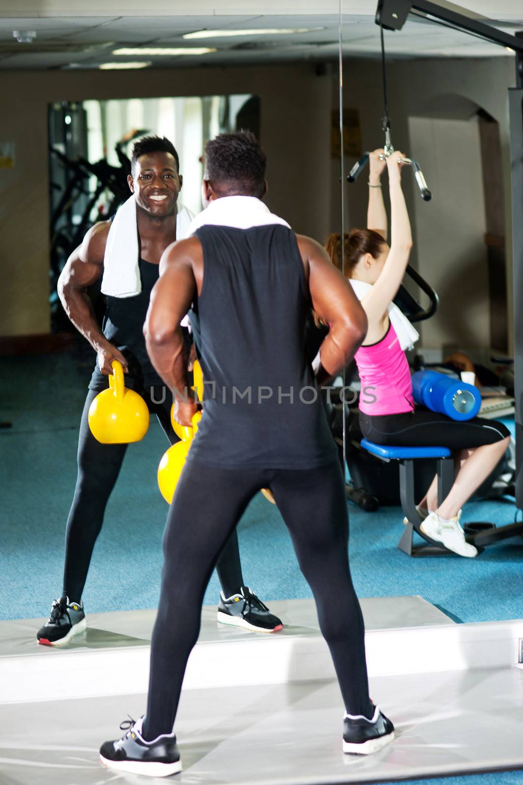 Mirror reflecting people working out in the gym