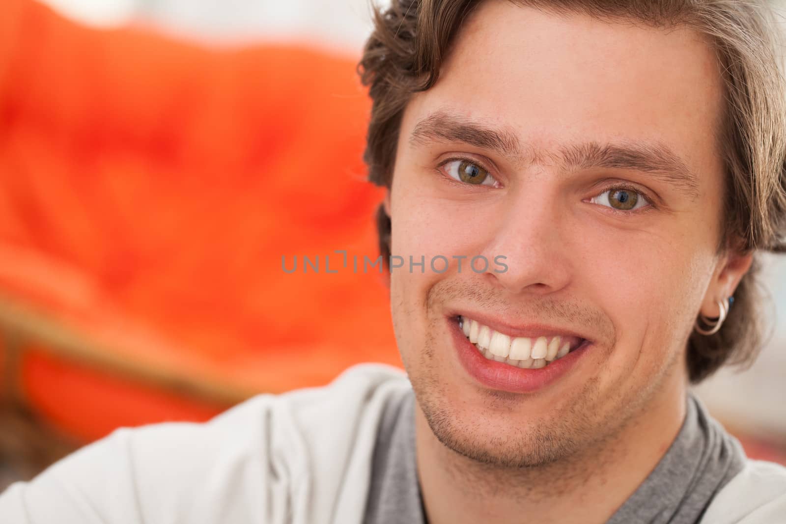 Portrait of young happy caucasian man at home