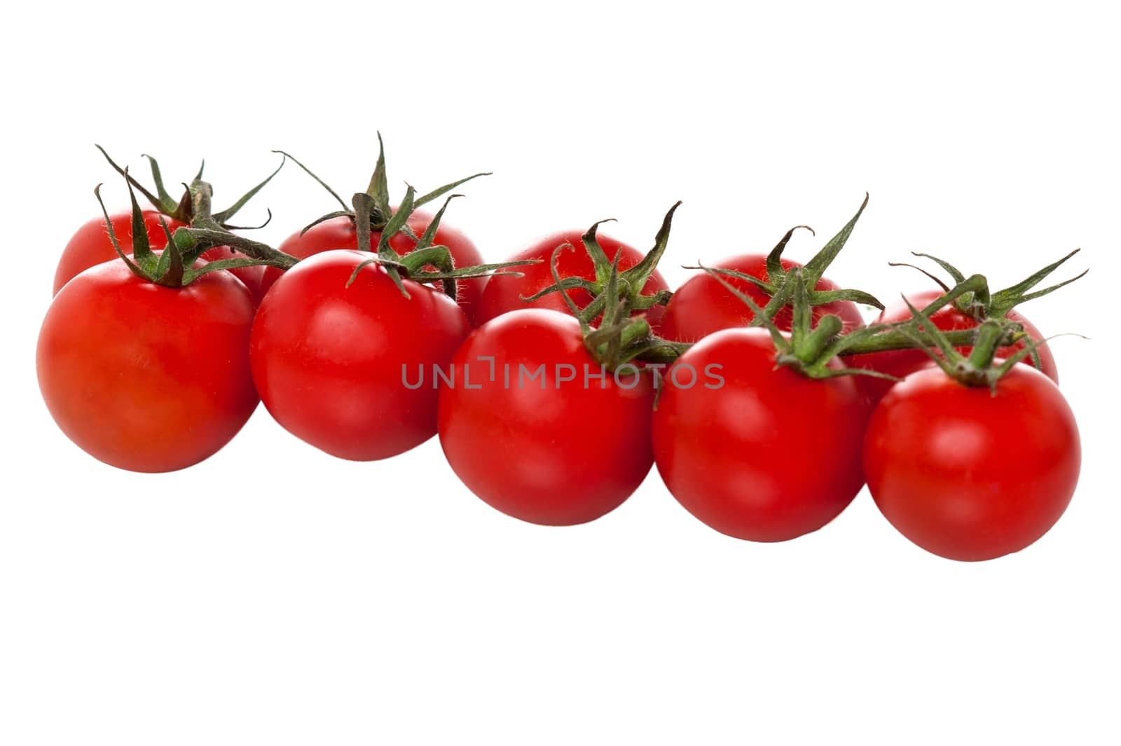 Cherry tomatoes arranged in a row by stockyimages
