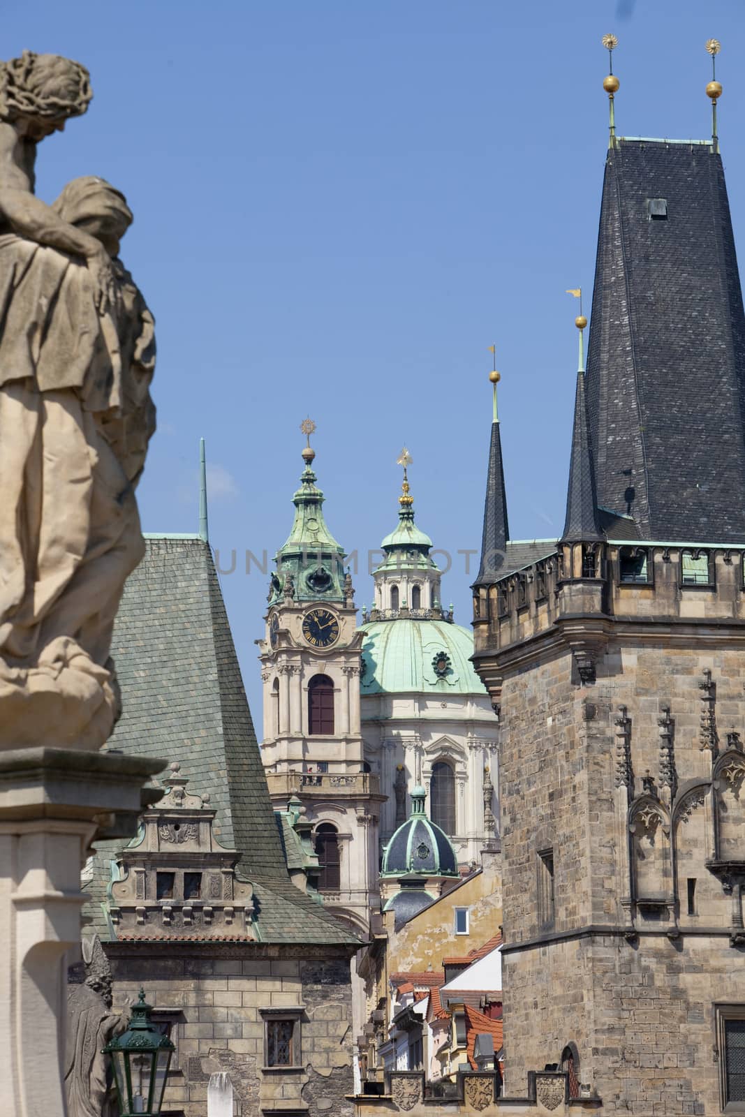 prague - different architectural styles-st. nicolas church and charles bridge tower