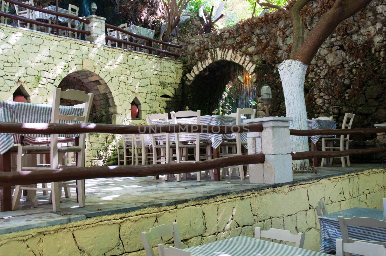 Typical greek taverna with tables outside .