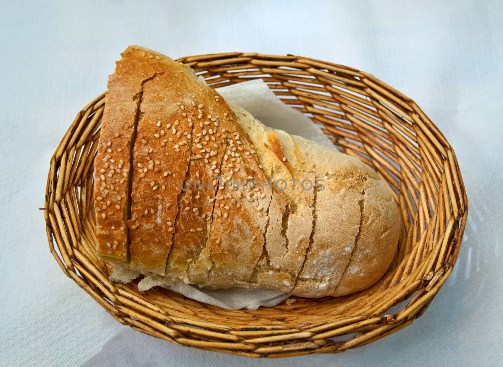 Bread with sesame seeds in a wicker basket.