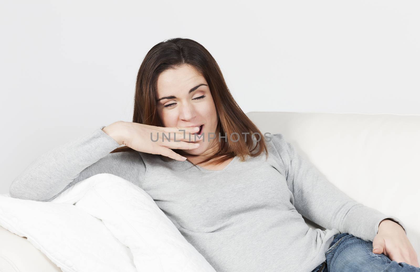 young attractive woman yawning on sofa