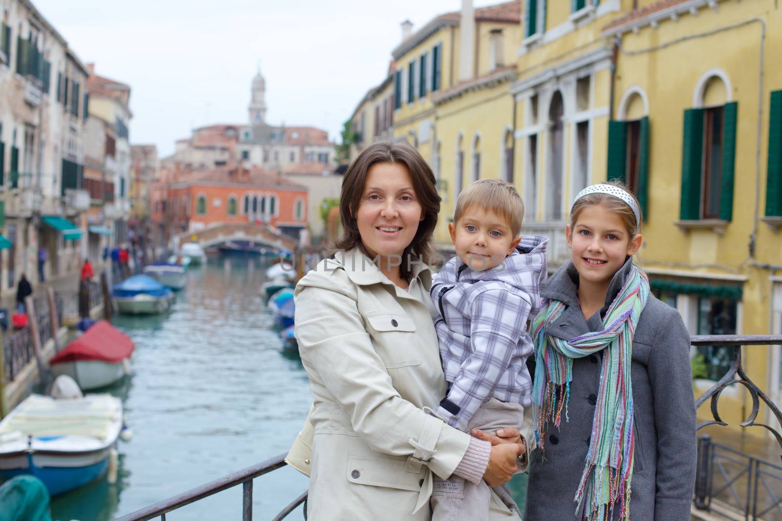 Summer venetian view and tourist - mother with kids. Venice, Italy