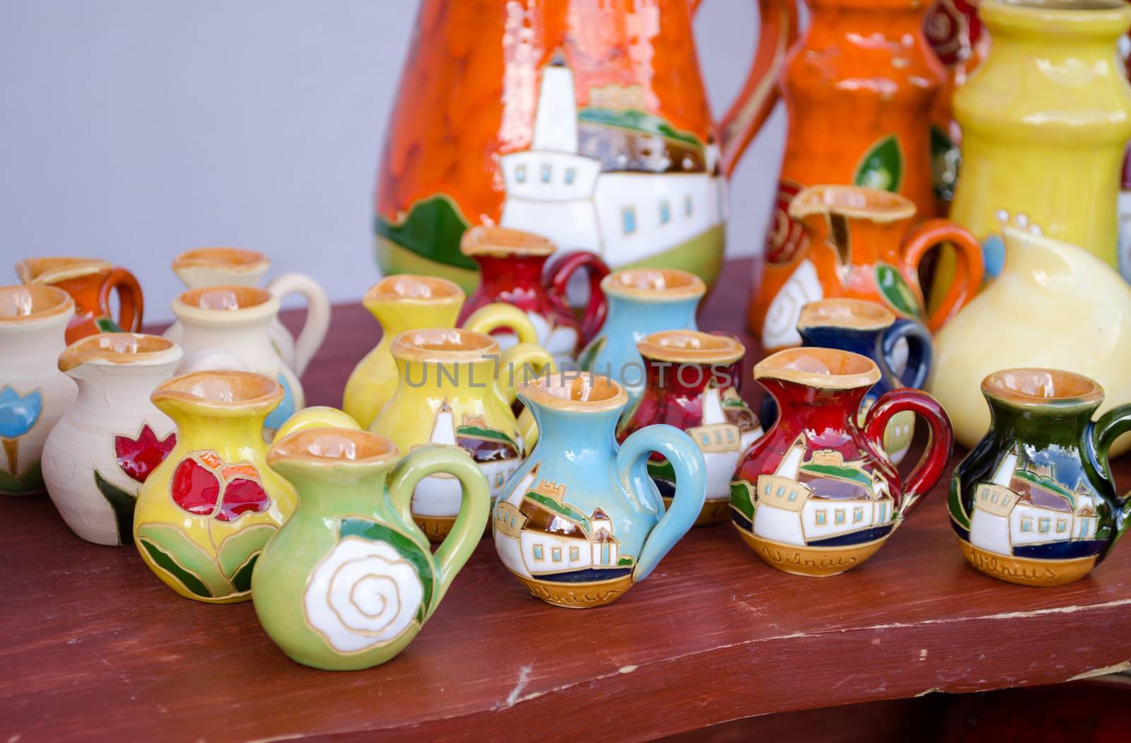 various colorful clay handmade craft jug jar sell in market.