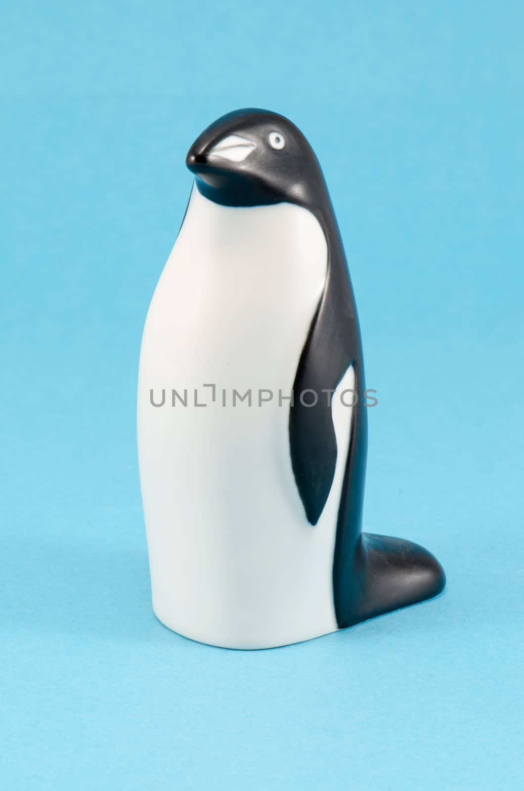 toy penguin figurine home decor on blue background by sauletas