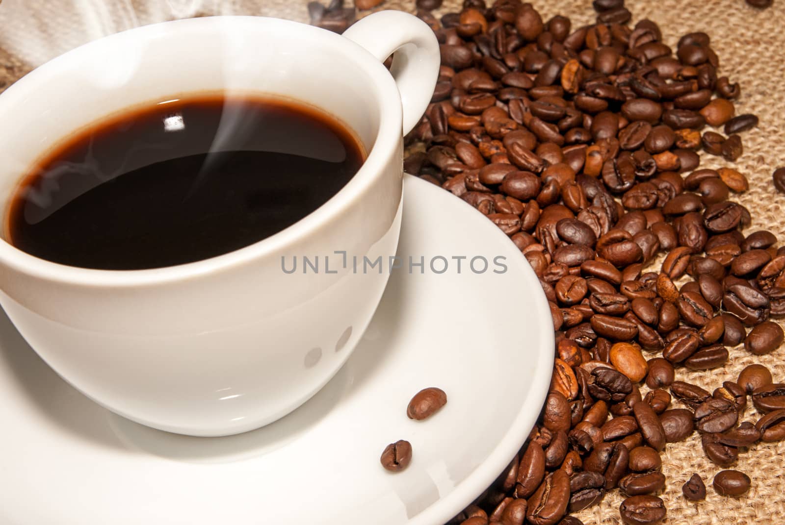 white cup hot coffee  and  scattered coffee grains