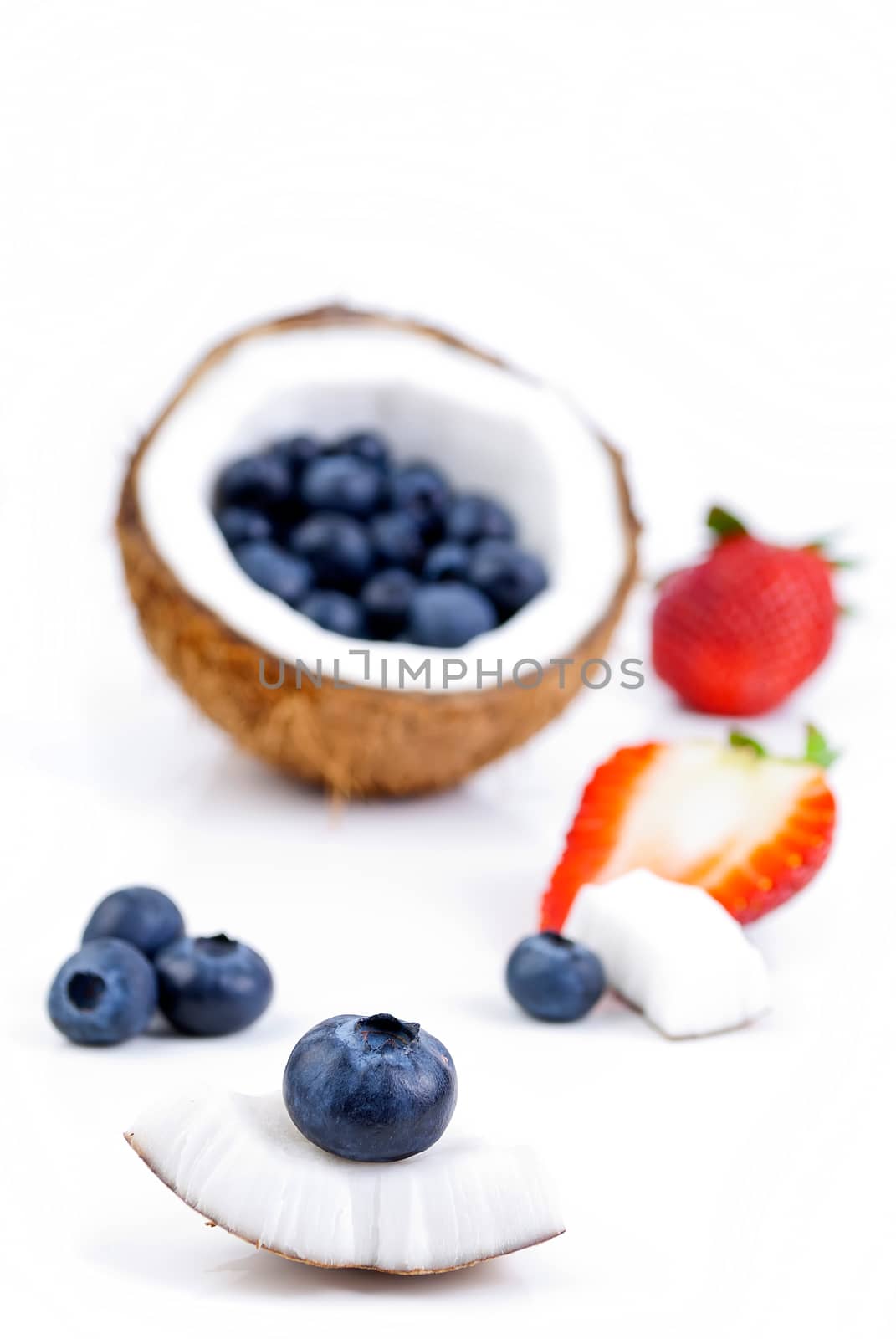 healthy fresh fruits - strawberry, blueberry and coconut isolated on white background