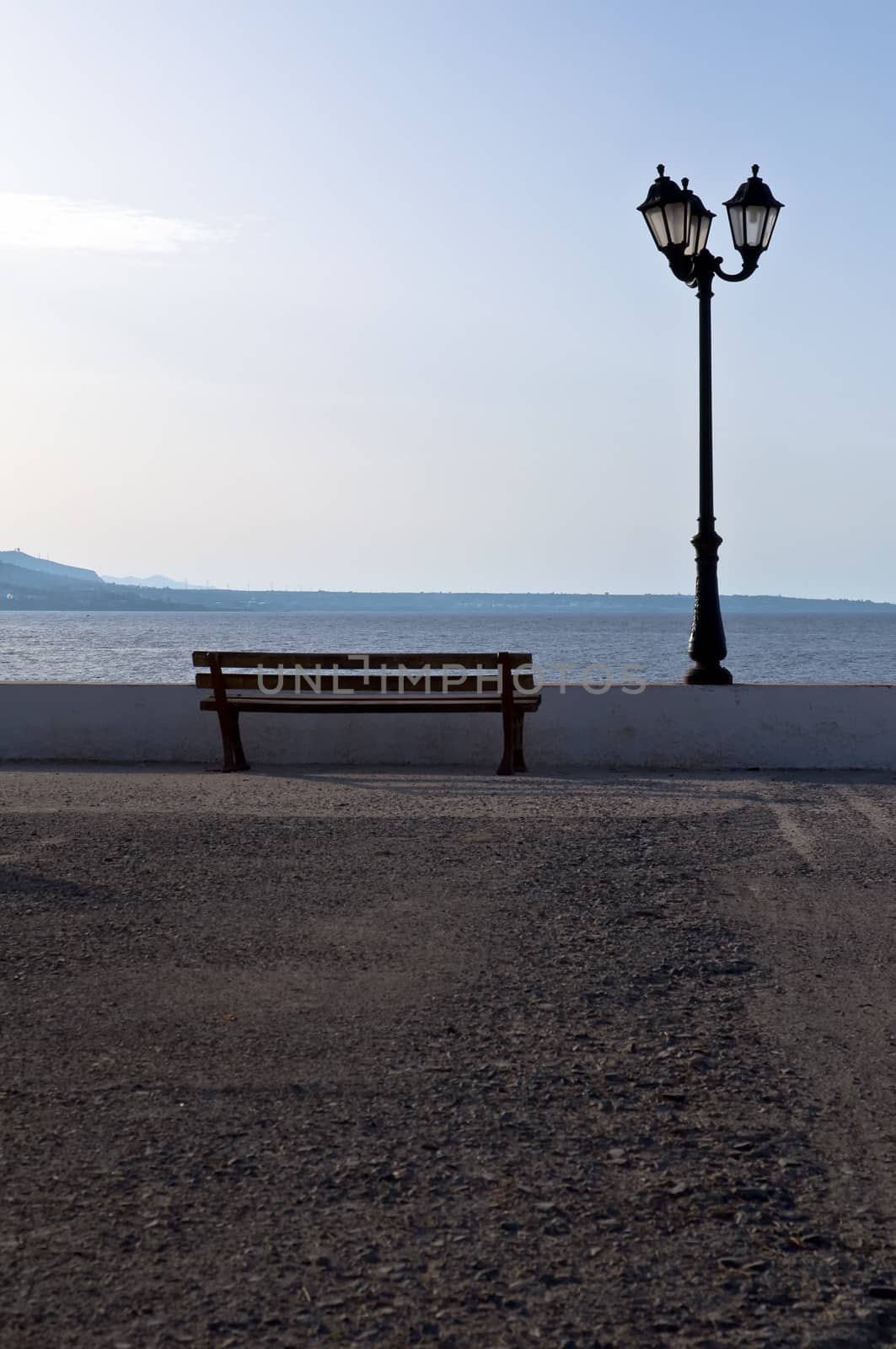 Empty wooden bench with a viewpoint looking out to sea.