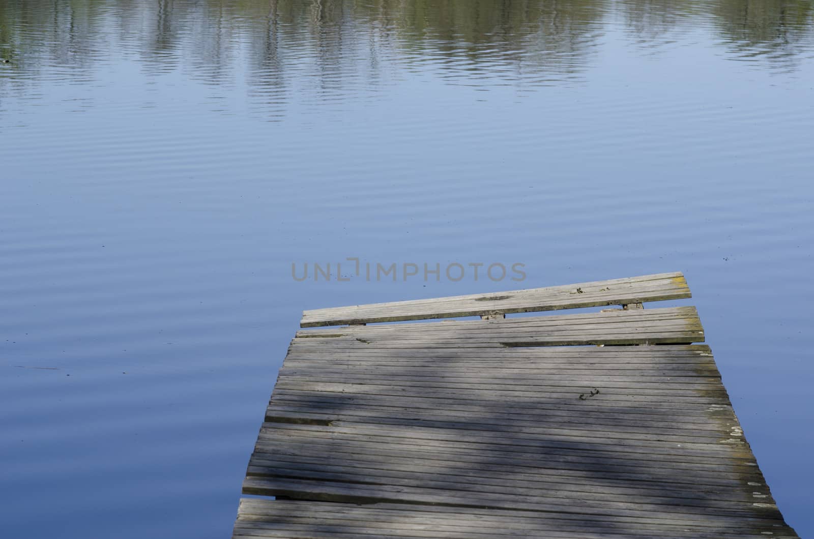 Empty wooden footpath and beautiful lake with sunlight and shadow