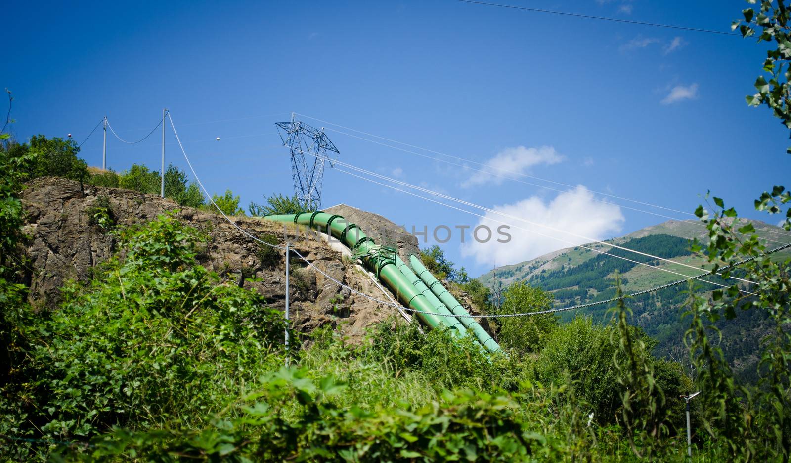 Hydroelectric plant pipes on mountain and electric power lines