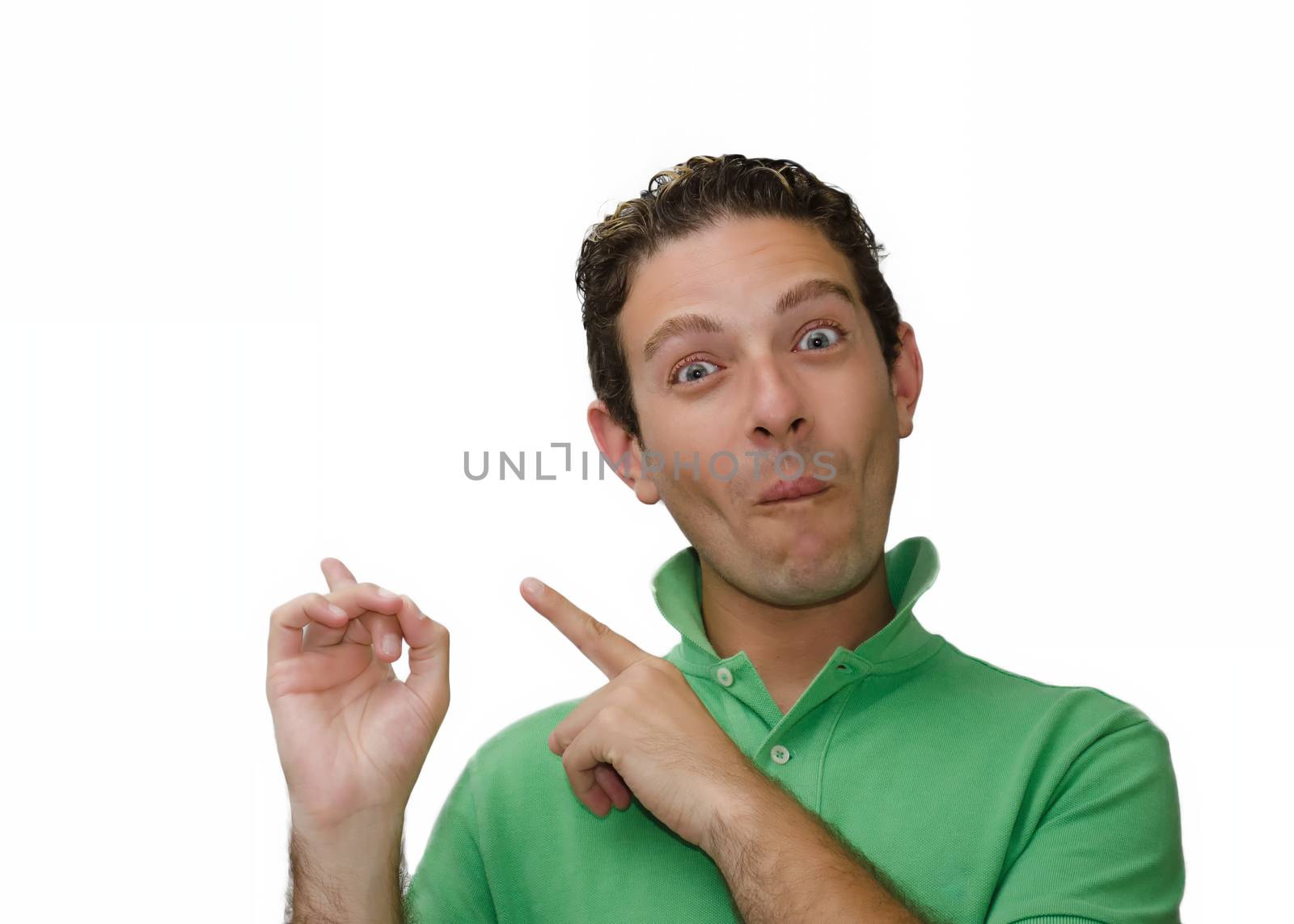Attractive young man with silly and funny face pointing fingers to empty copy space