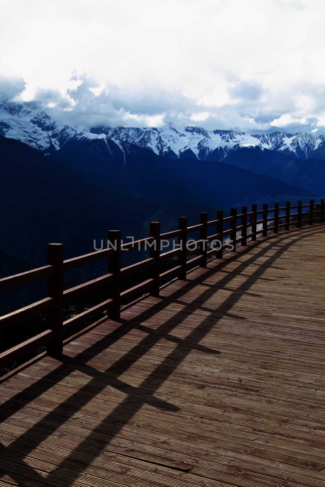 Wood floor with a background of mountains and clouds