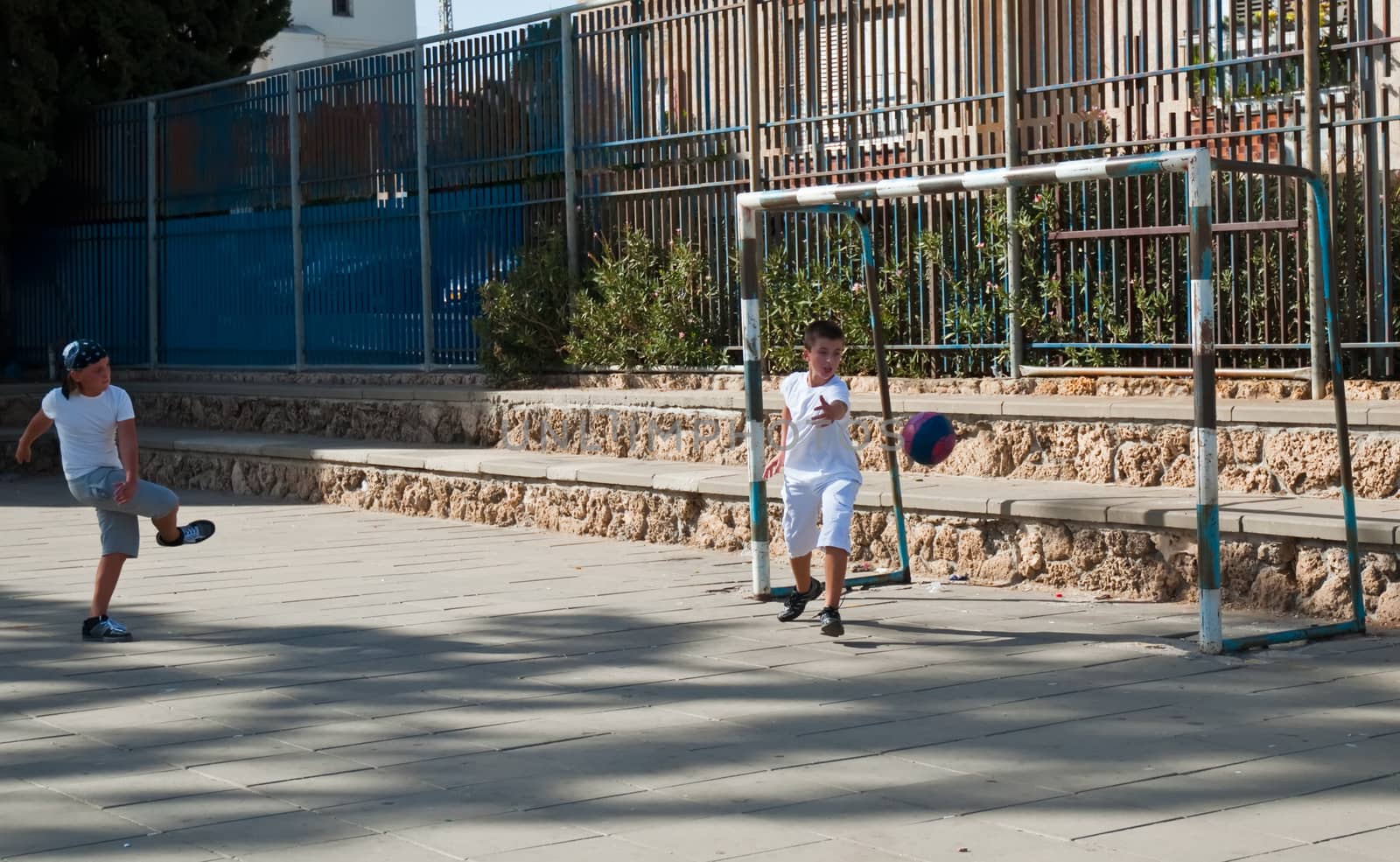 Teenage boys playing soccer at sunny day .