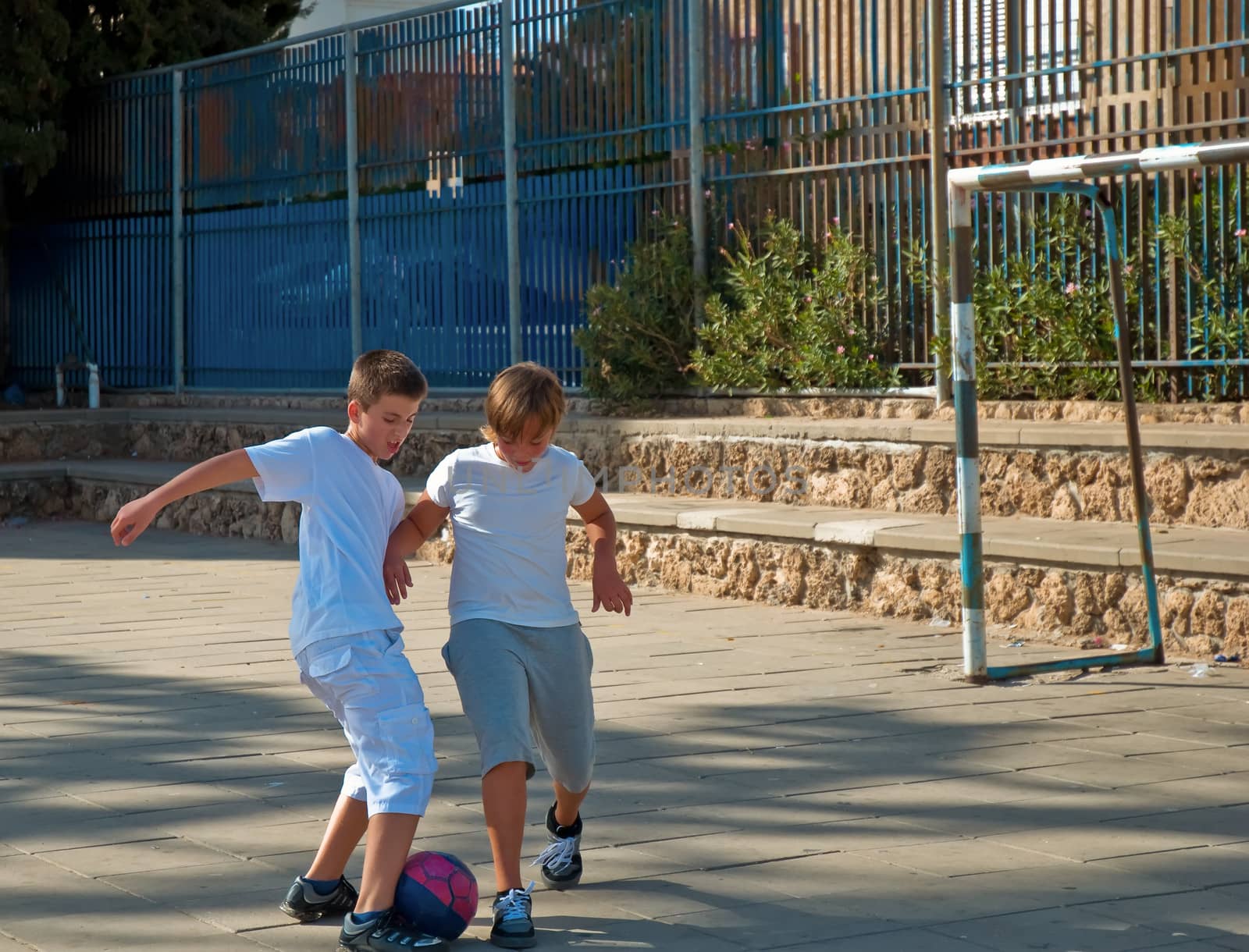 Teenage boys playing soccer at sunny day .