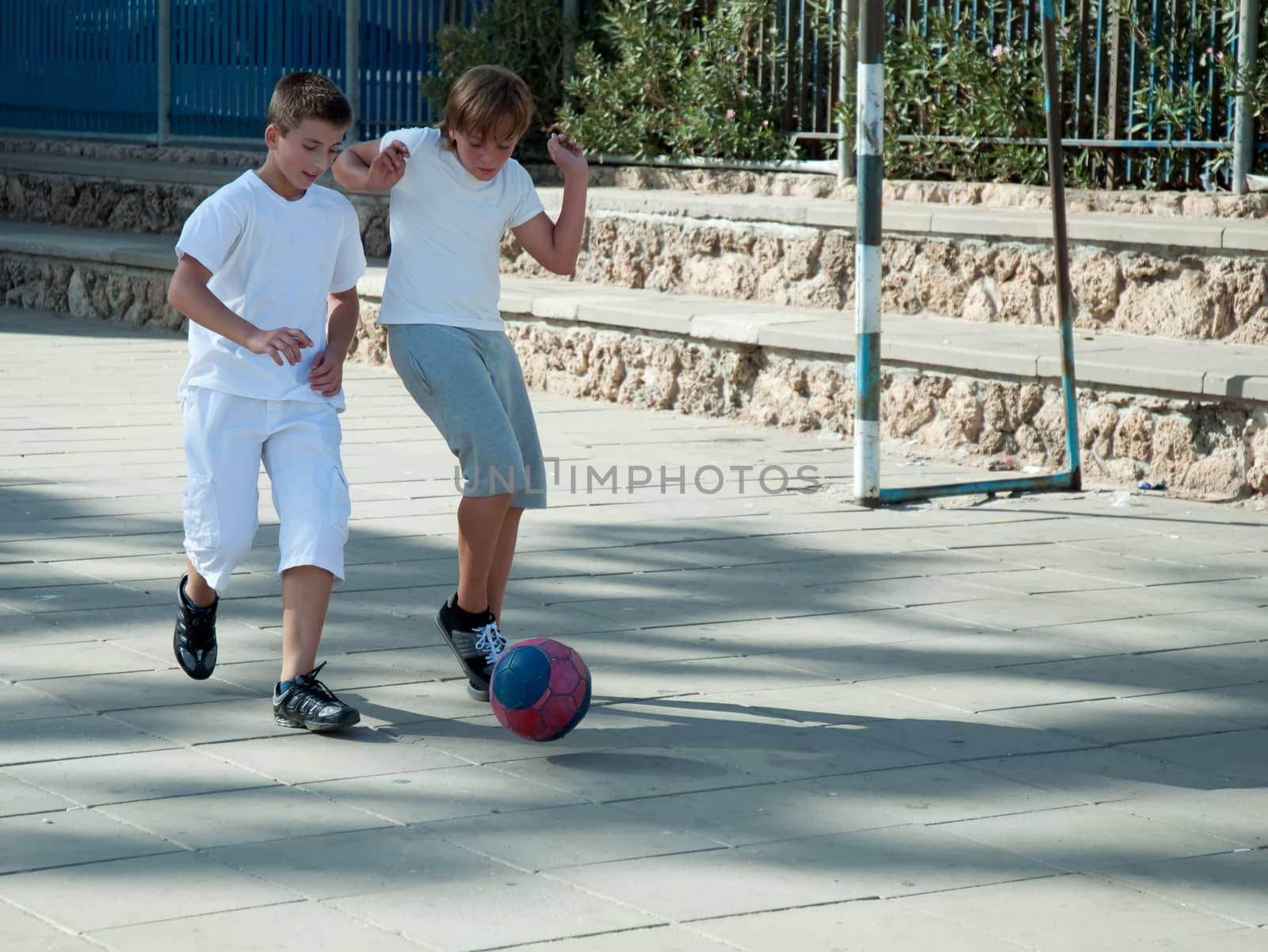 Teenage boys playing soccer at sunny day .