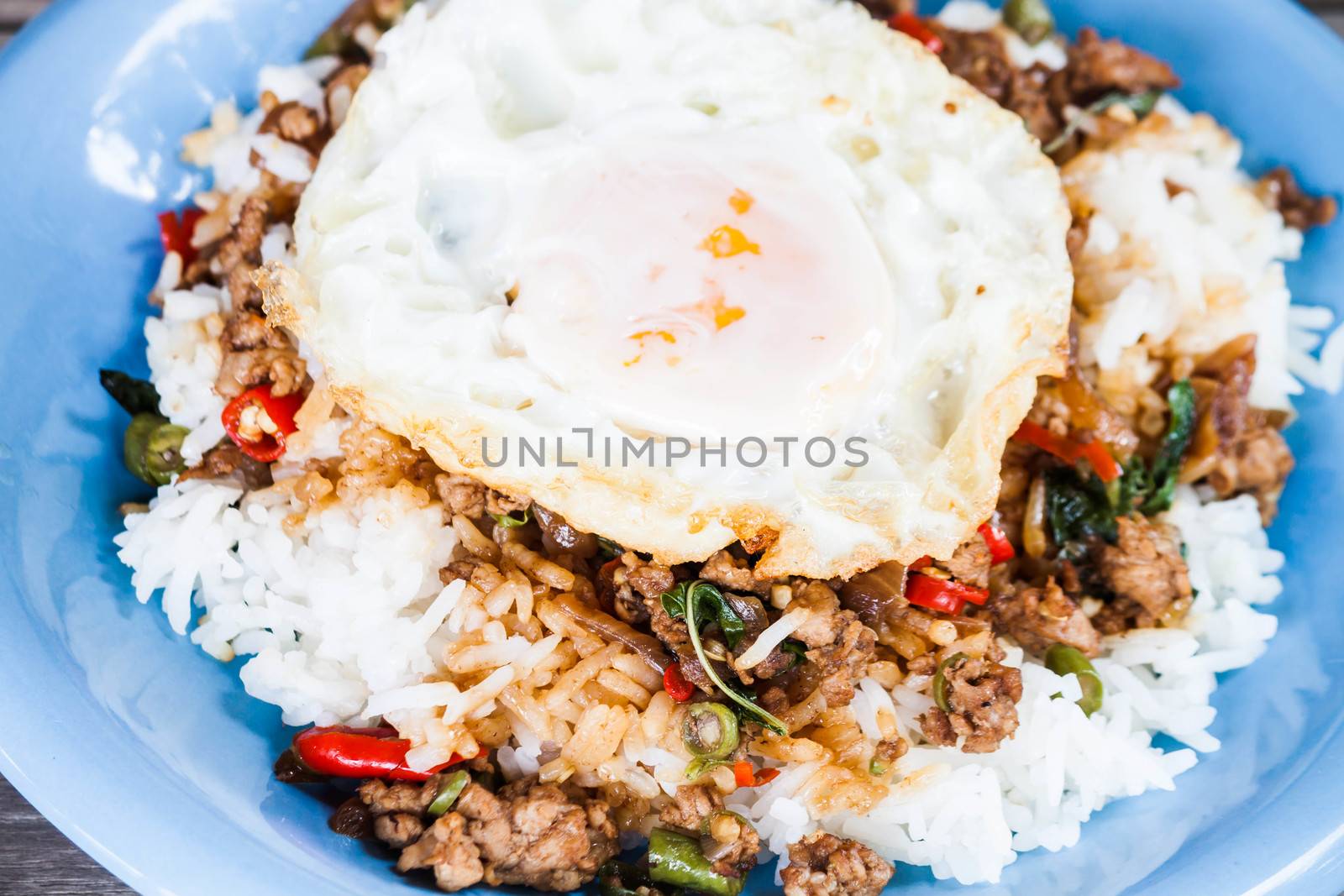 Closeup fried egg of rice stir fried pork and basil