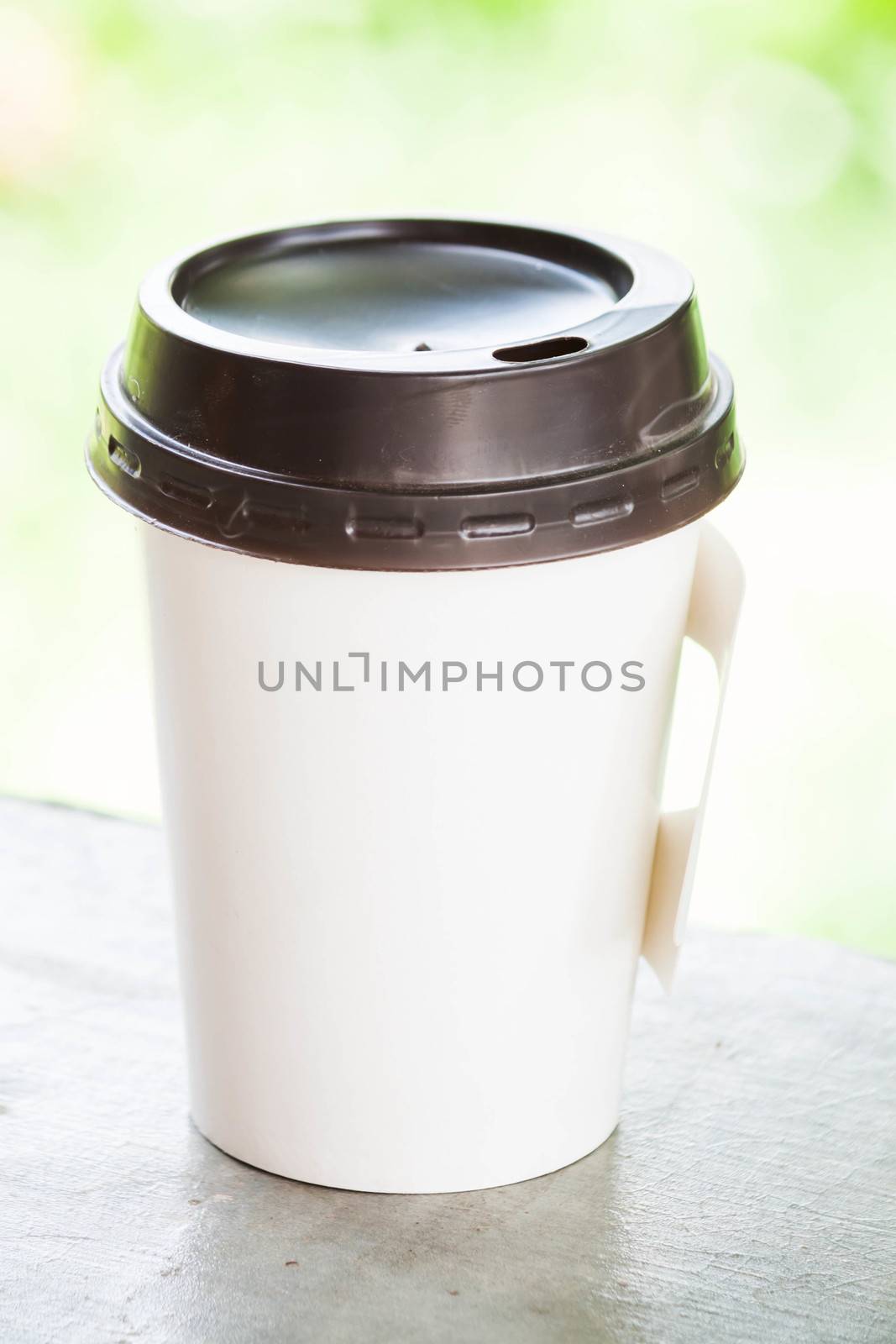 Hot coffee paper cup with green bokeh  by punsayaporn