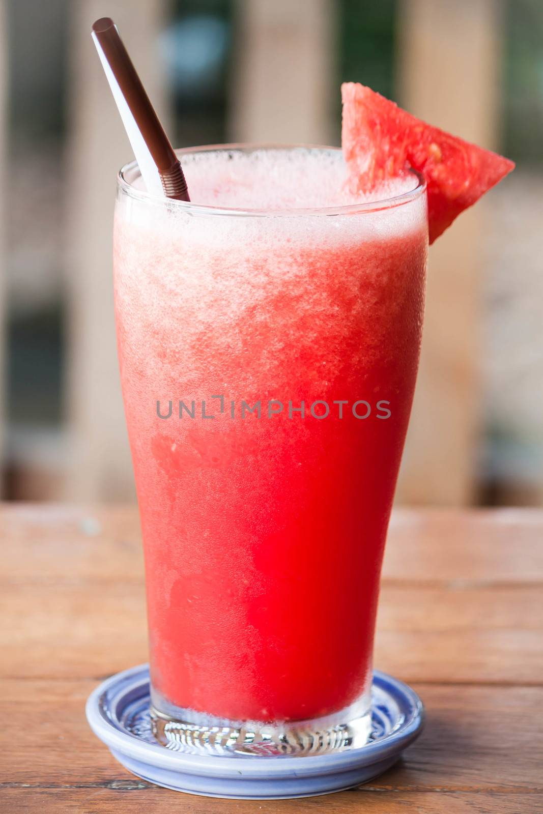 Red water melon fruit juice frappe on wood table by punsayaporn