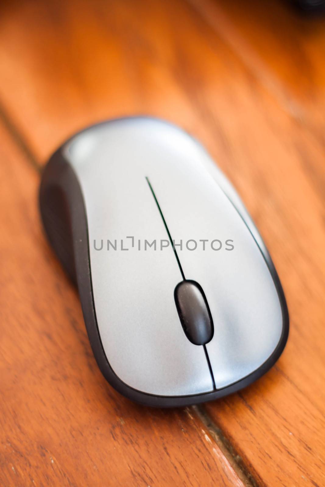 Silver wireless mouse on wood table by punsayaporn