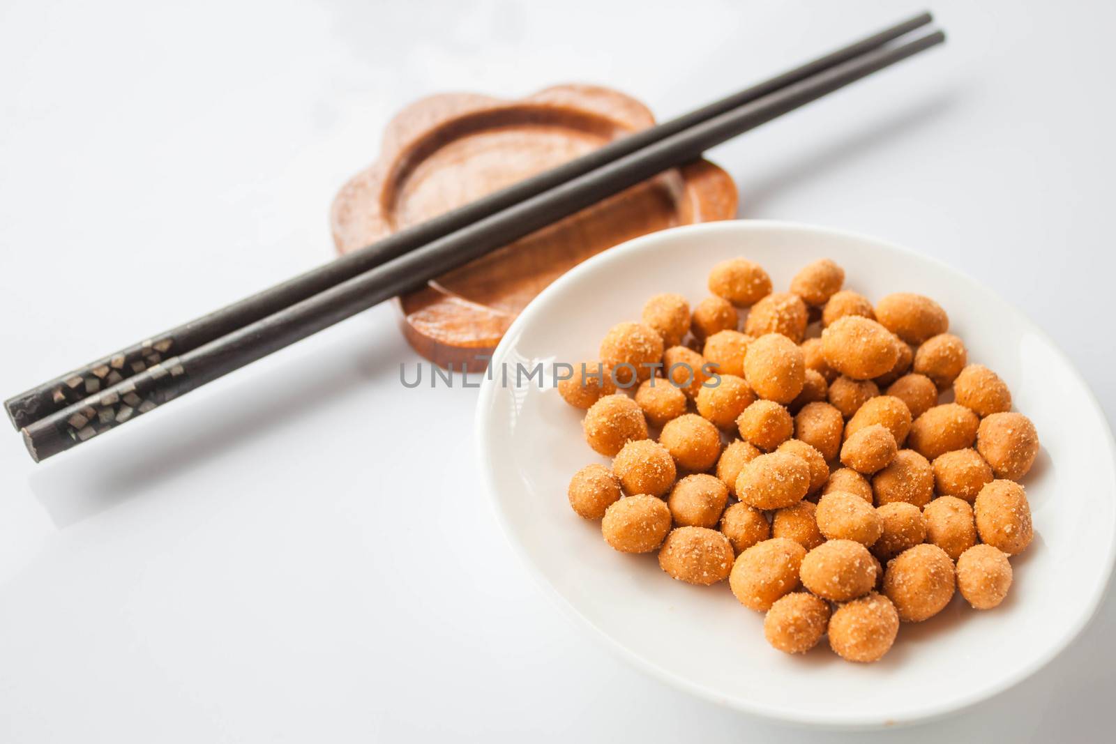 Spicy peanuts snack and chopsticks on white table  by punsayaporn