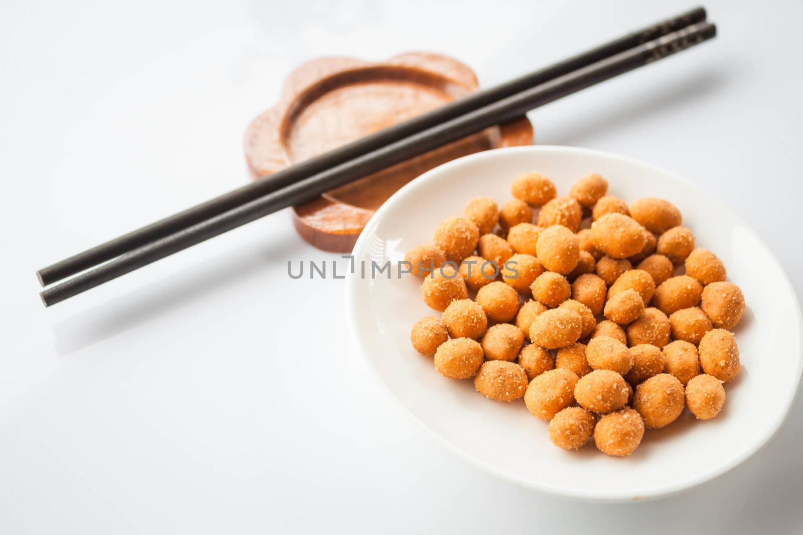 Peanuts snack coated with spicy seasoning and chopsticks by punsayaporn