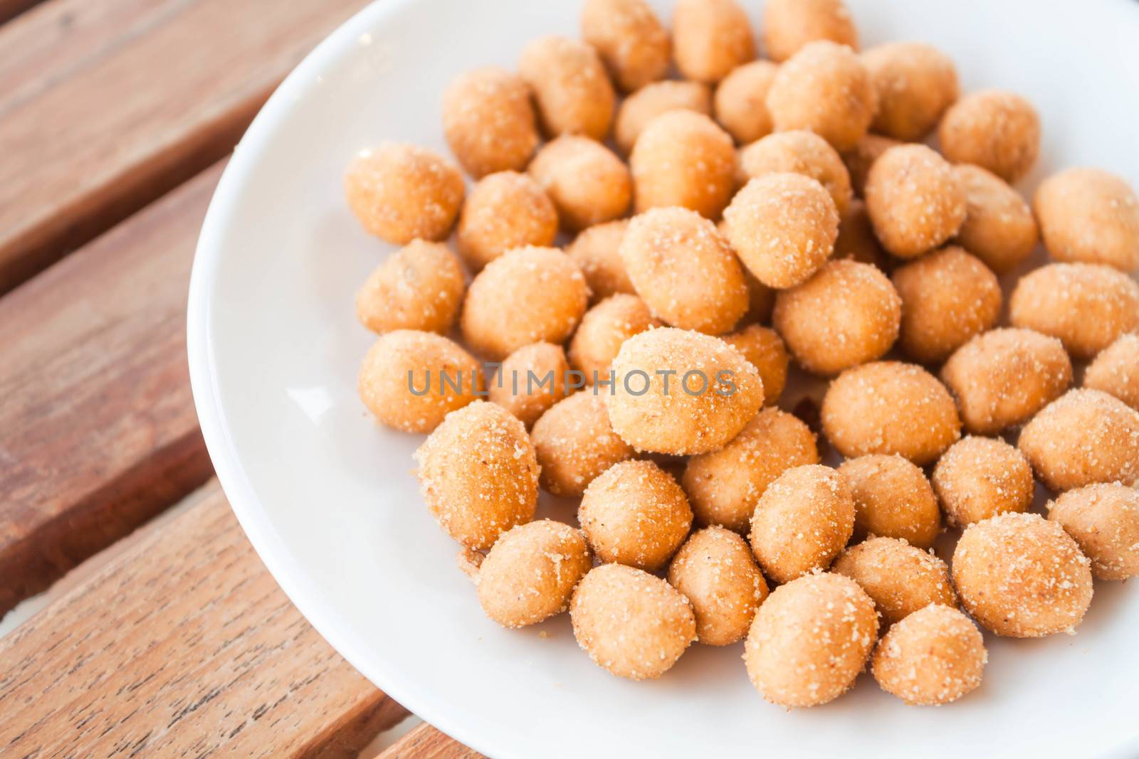 Close up of spicy peanuts snack on white dish  by punsayaporn