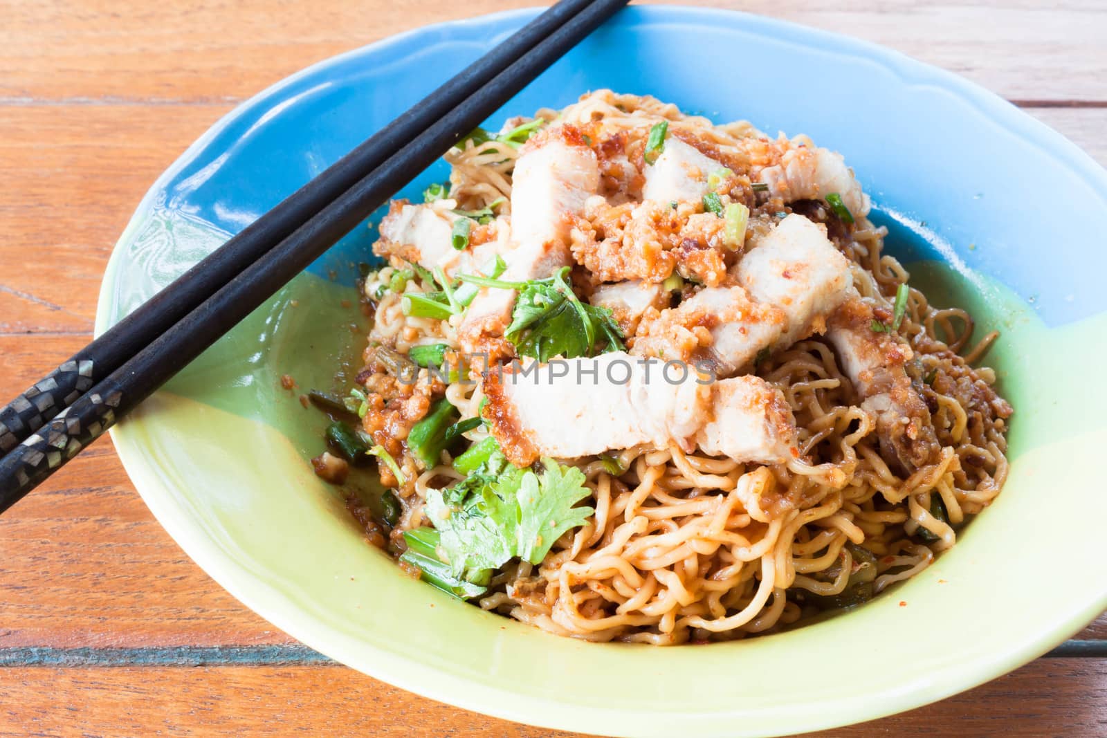 Spicy stir fried noodles with crispy pork and chopstick by punsayaporn