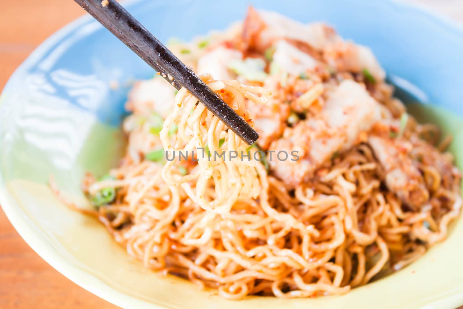 Close up chopstick holding a group of yellow noodles