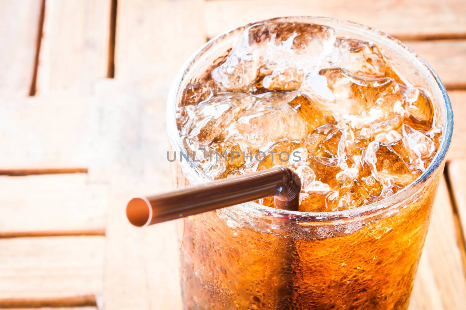 Fresh cola drink with ice on wood table