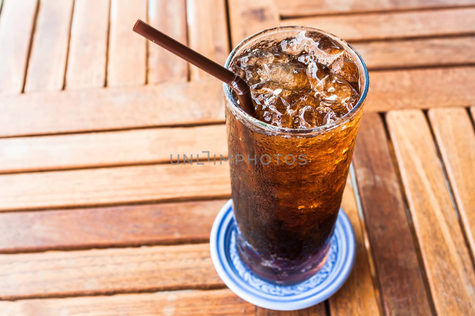 Fresh black soda with ice on wood table by punsayaporn