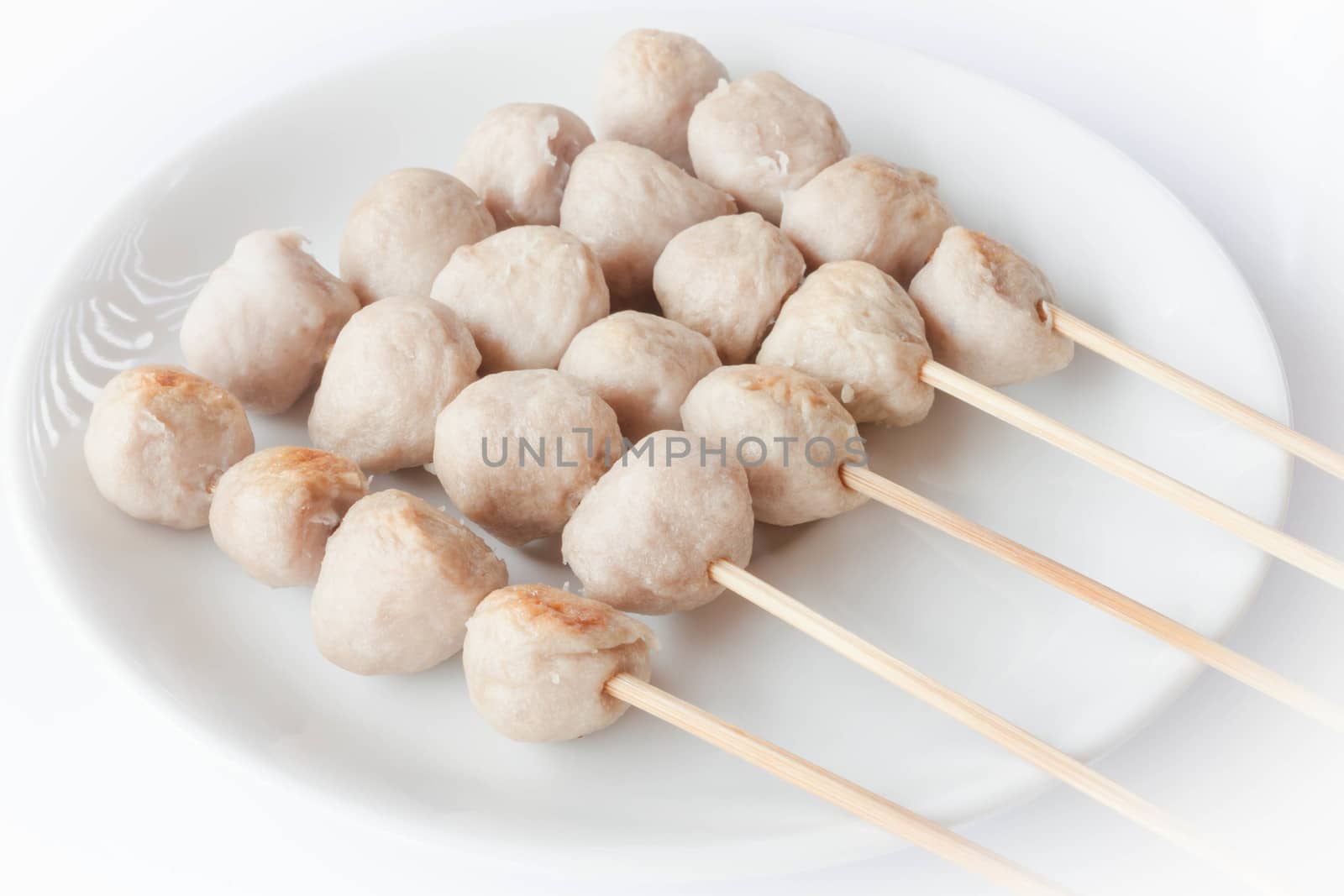 Mini pork balls in white plate on clean table by punsayaporn