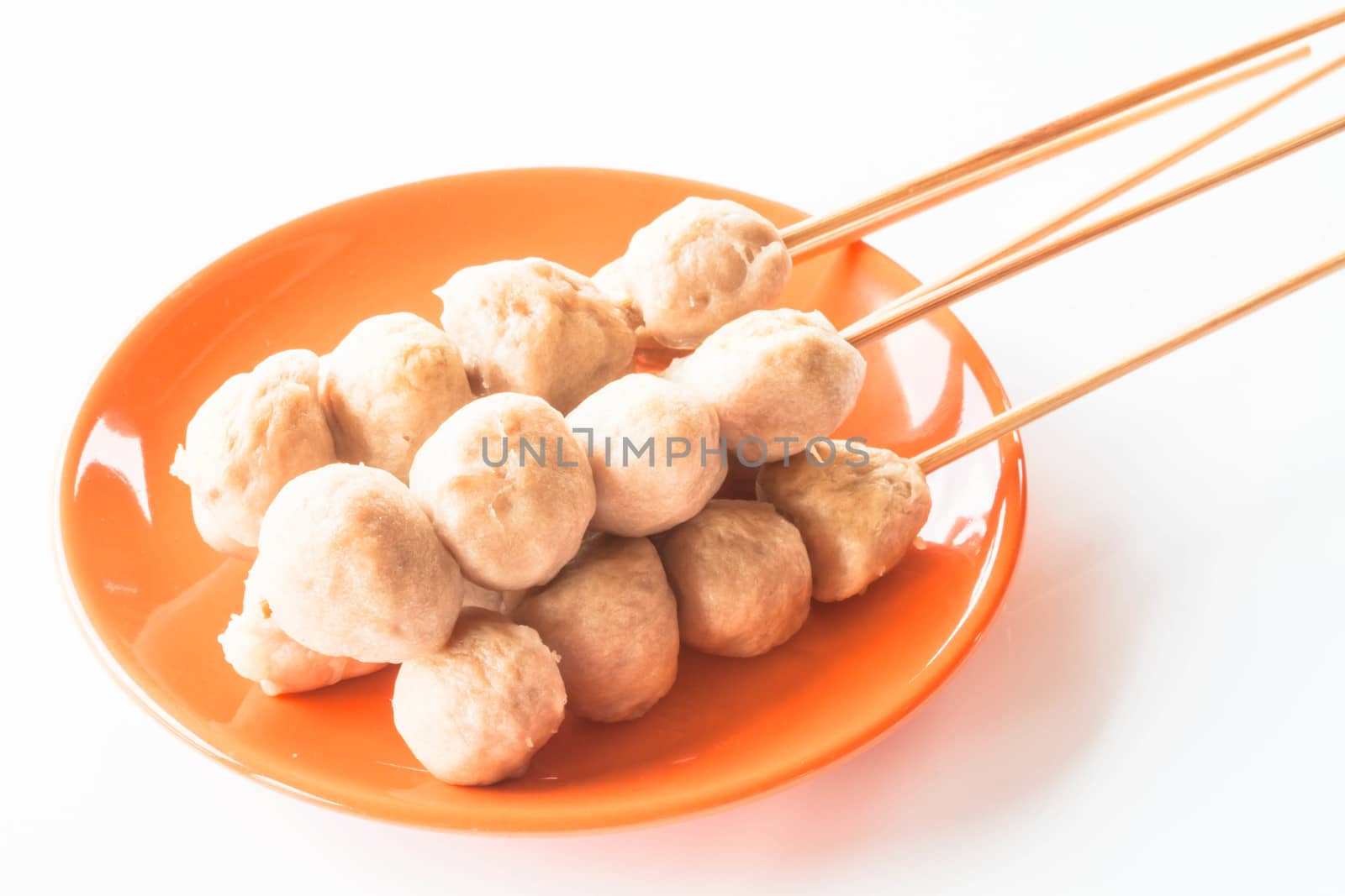 Mini pork balls in orange dish on clean table by punsayaporn